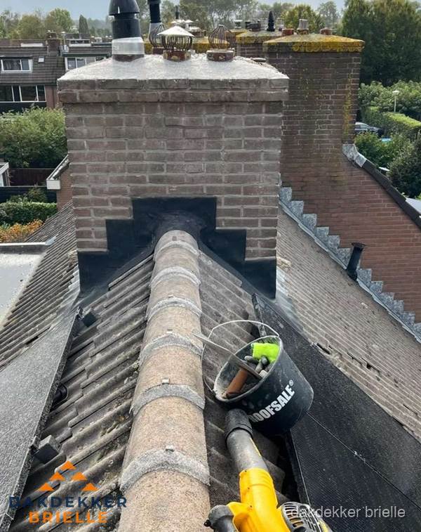 Schoorsteen met loodaansluiting en nokvorst op pannendak in Brielle Schoorsteen met loodaansluiting en nokvorst op pannendak in Brielle