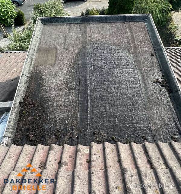 Verouderd plat dak met bitumen en slijtage voor lekkage inspectie in Brielle Verouderd plat dak met bitumen en slijtage voor lekkage inspectie in Brielle