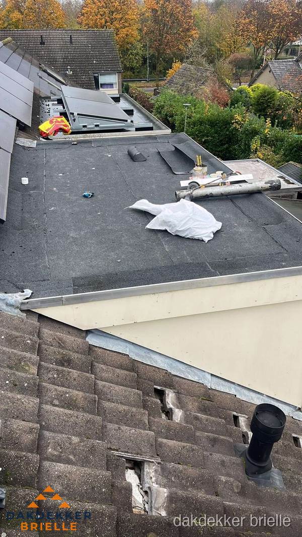 Beschadigde dakbedekking op plat dak voor reparatie in Brielle