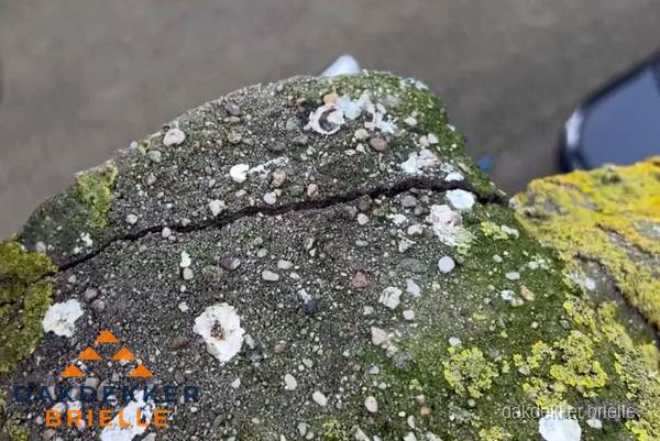 Beschadigde en verweerde nokvorst met scheuren en mos in Brielle