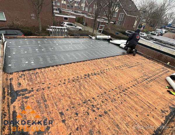 Dakdekker legt onderlaag op plat dak met houten constructie in Brielle Dakdekker legt onderlaag op plat dak met houten constructie in Brielle