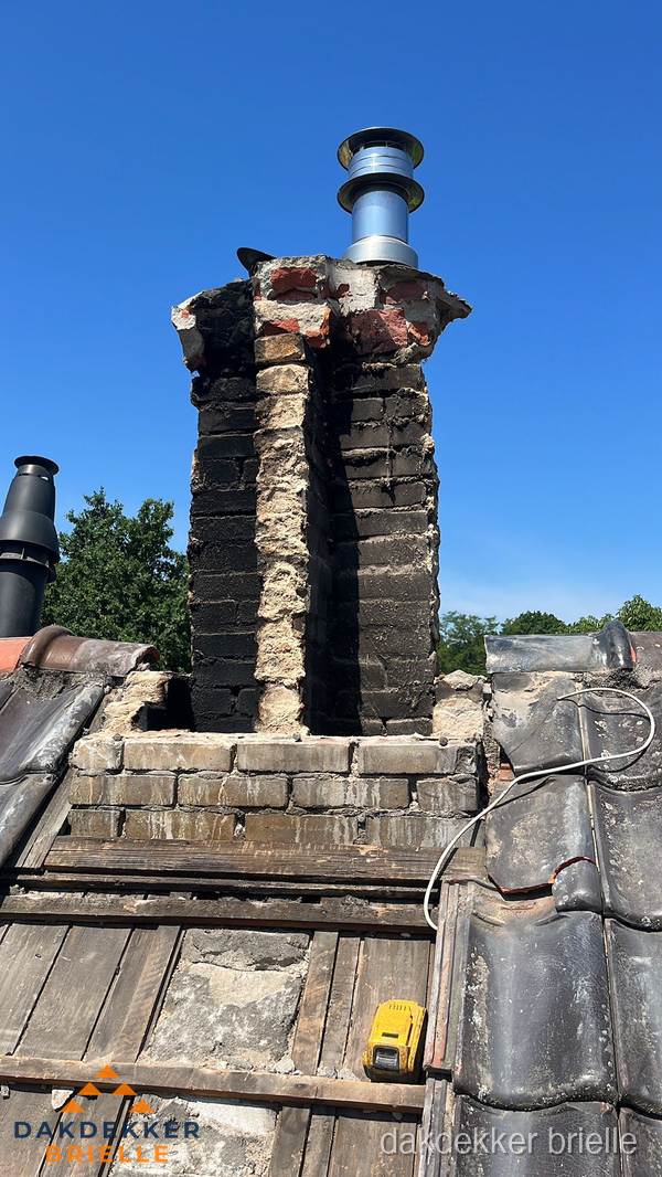 Beschadigde schoorsteen met nieuwe rookgasafvoer op oud dak in Brielle Beschadigde schoorsteen met nieuwe rookgasafvoer op oud dak in Brielle