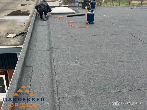Dakdekker repareert bitumen dakbedekking op groot plat dak in Brielle Dakdekker repareert bitumen dakbedekking op groot plat dak in Brielle