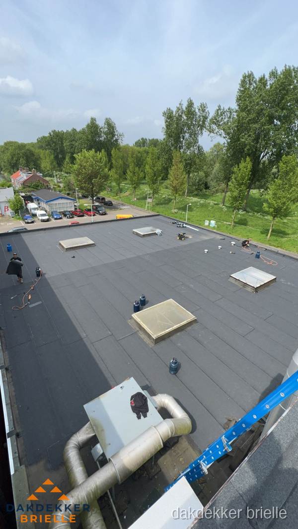 Dakdekker aan het werk op groot plat dak met bitumen in Brielle Dakdekker aan het werk op groot plat dak met bitumen in Brielle
